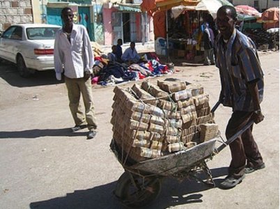 Man-carrying-money-in-wheelbarrow.jpg